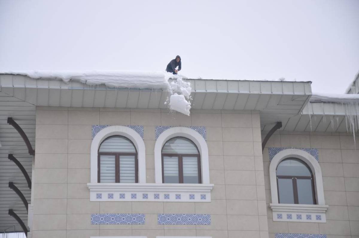 Muş'ta işçiler bellerine bağladıkları iplerle çatılarda kar temizliği yapıyor