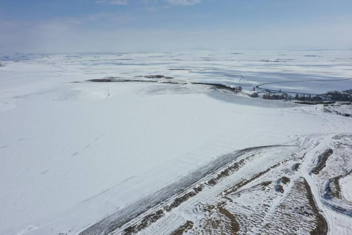 Kars'ta yüzeyi buz kaplı Bayburt Barajı kar yağışıyla beyaza büründü