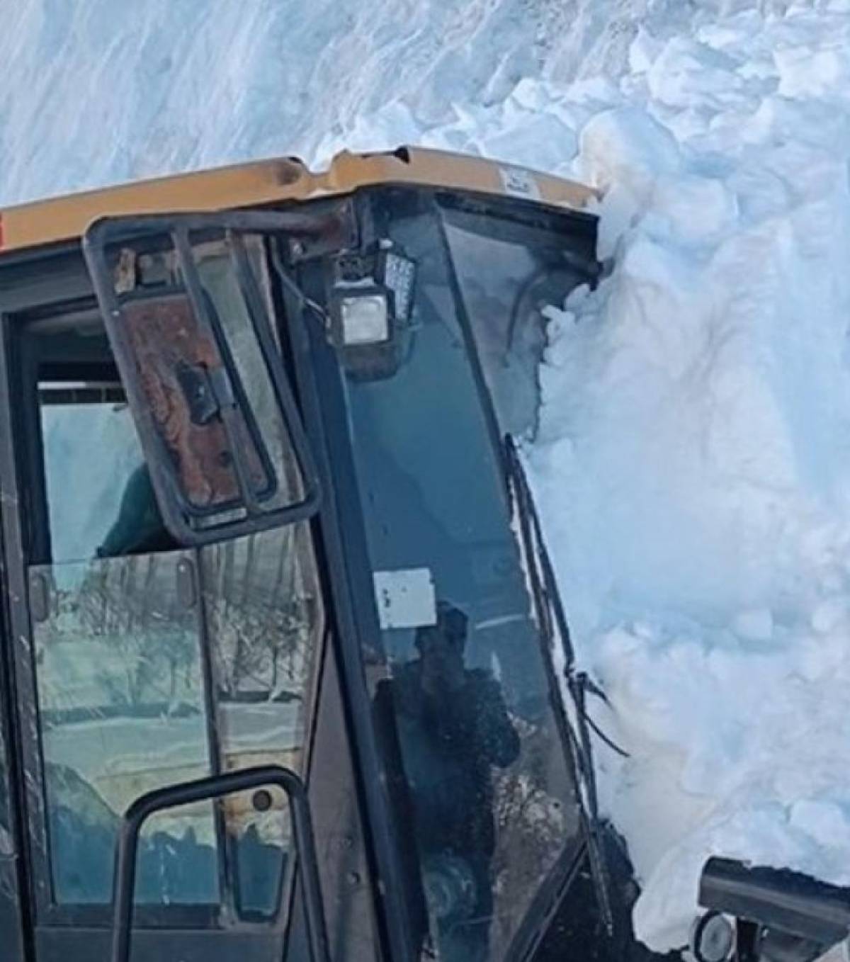 Hakkari'de mahalle yolunu açmaya çalışan iş makinesinin üzerine çığ düştü